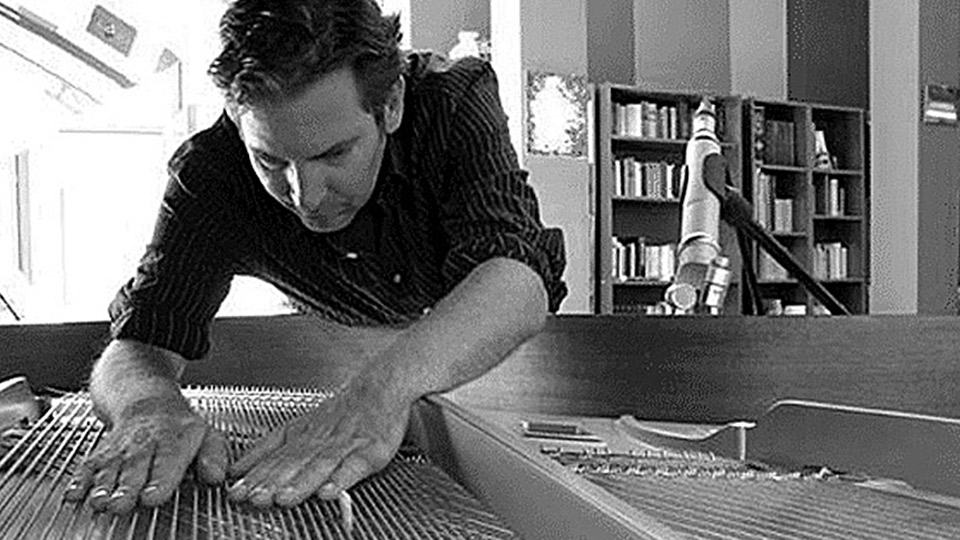 Andreas F. Staffel bending into a piano grand piano