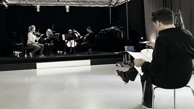 Andreas F. Staffel with sheet music during rehearsals with a string quartet